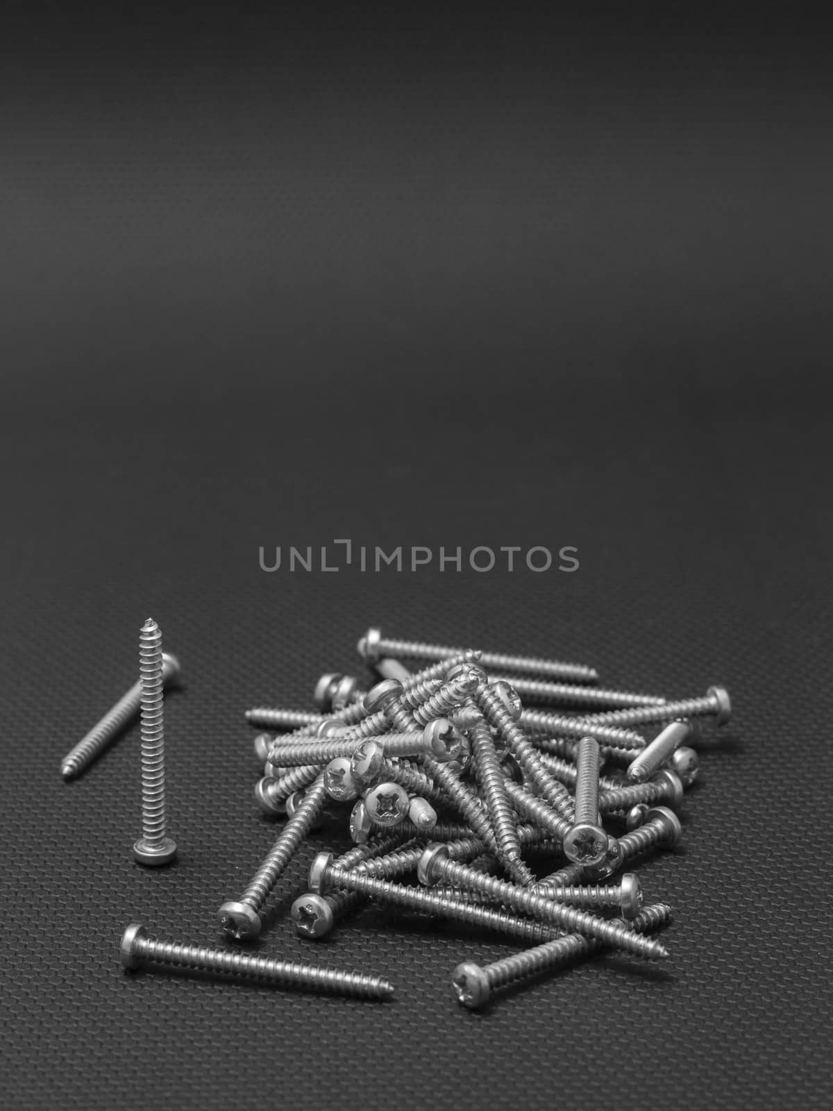Screws located on a black background by mailos
