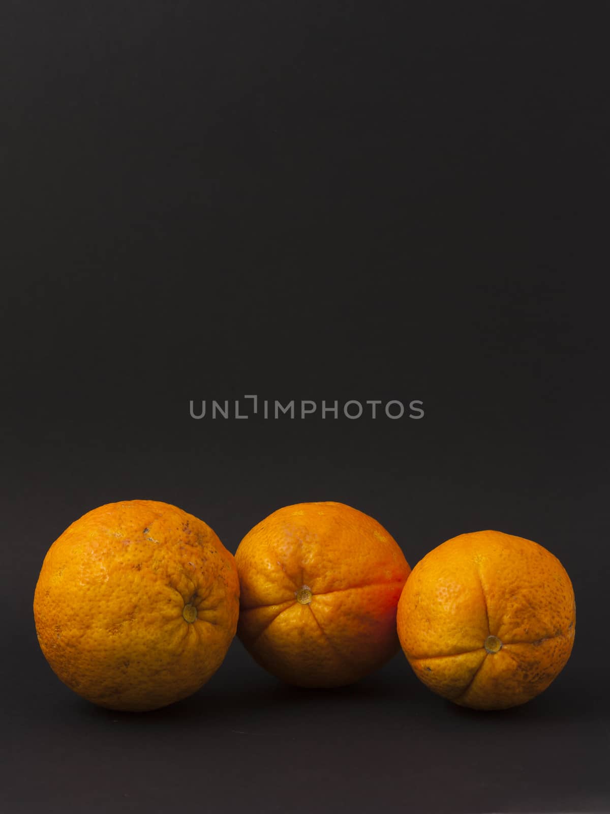 Three oranges on a black background by mailos