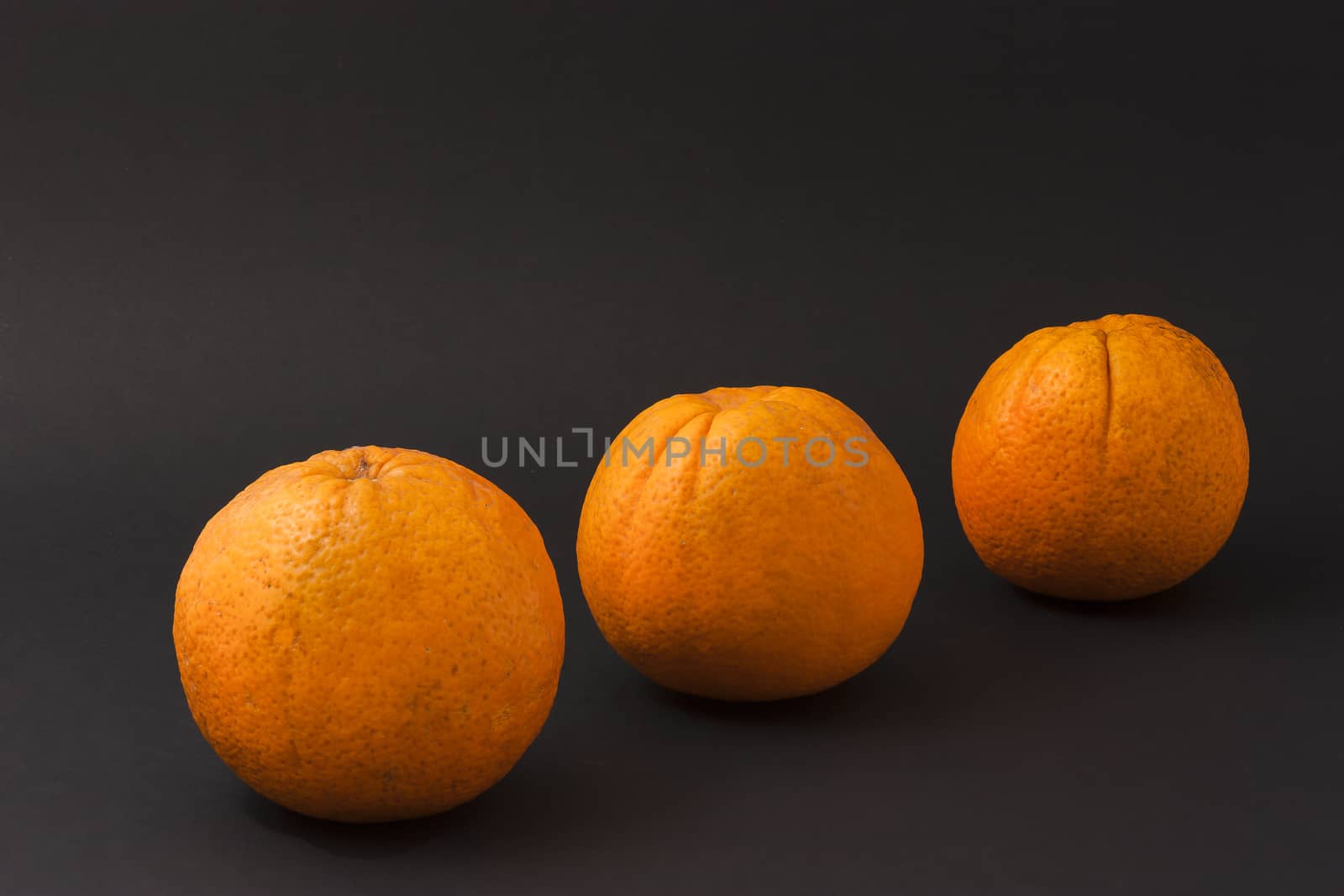 Three oranges on a black background by mailos