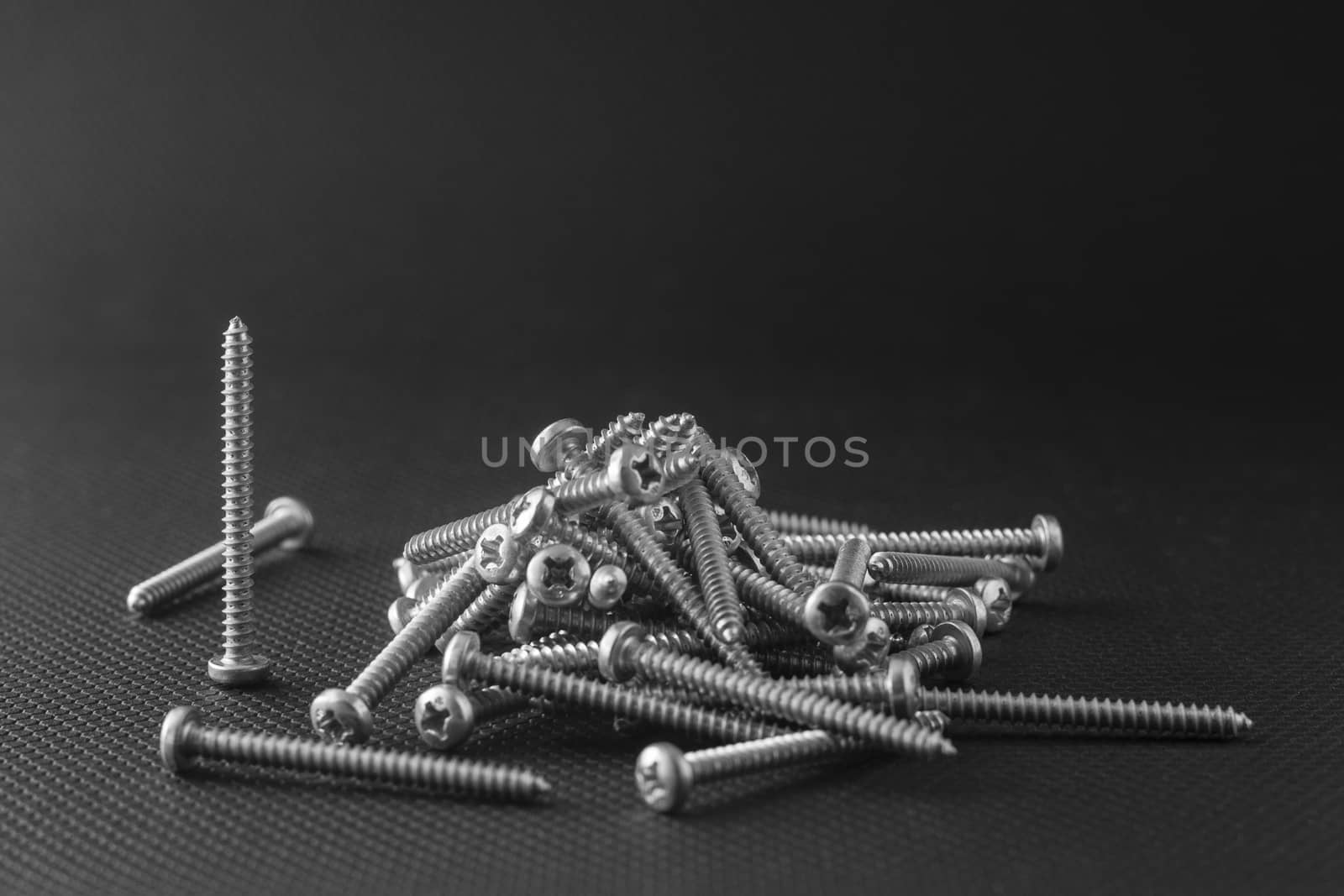 Screws located on a black background by mailos