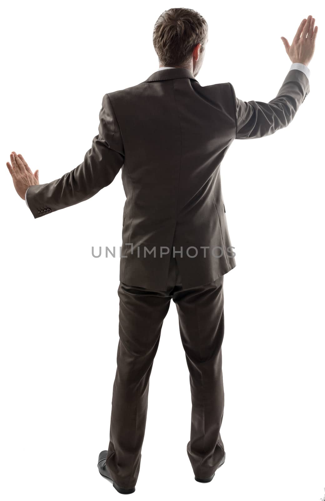 Rear view of young business man pointing at copy space isolated over white background, full length portrait of businessman standing back