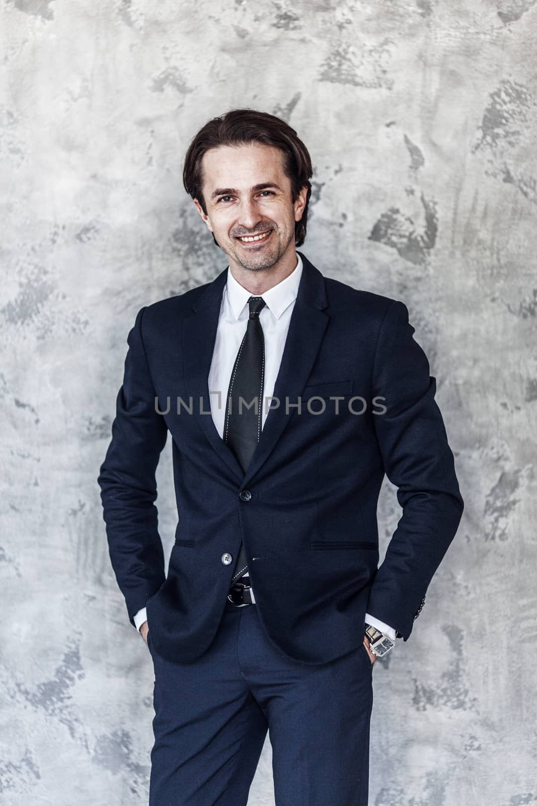 Portrait of businessman posing against a concrete wall