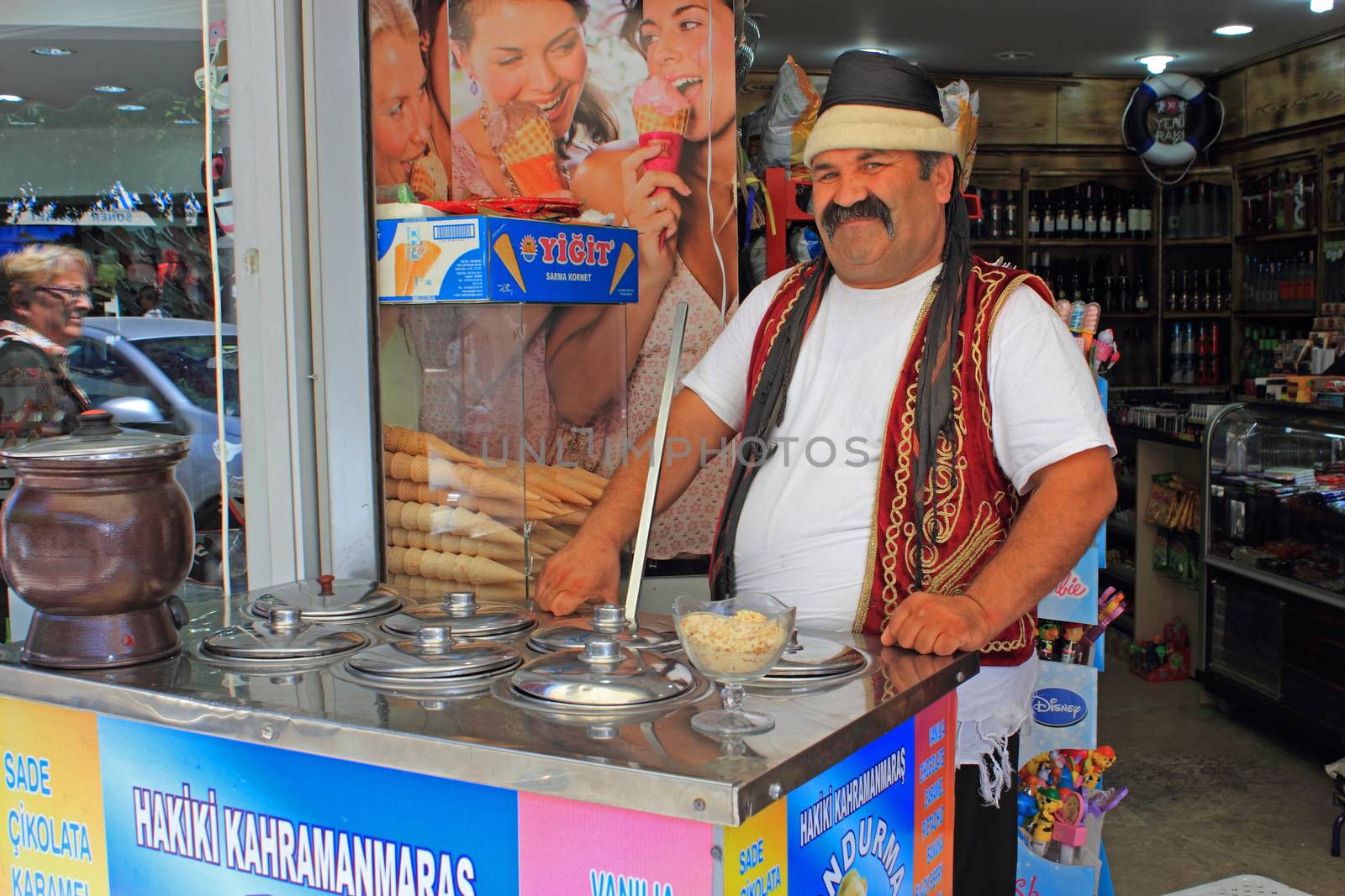 An ice cream seller, dressed in traditional turkish costume, waiting for customers.