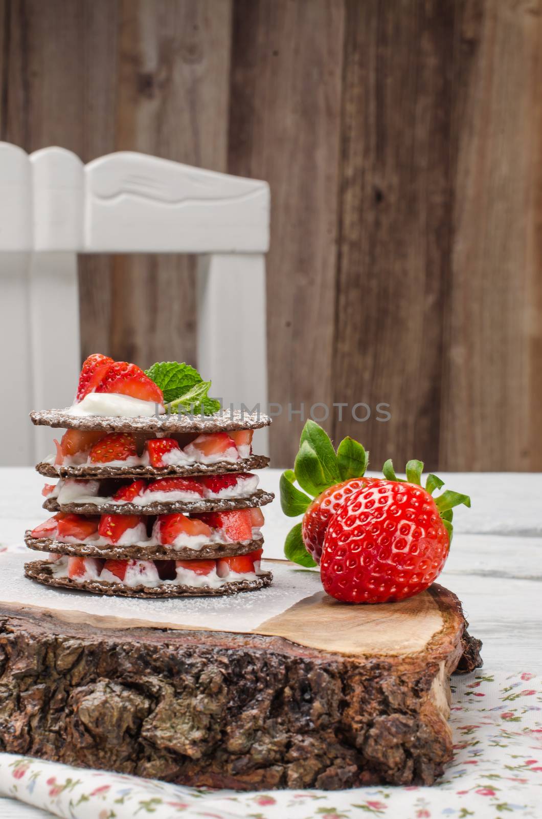 Chocolate belgian waffles with strawberries, whipped cream and mint leaf on wooden table