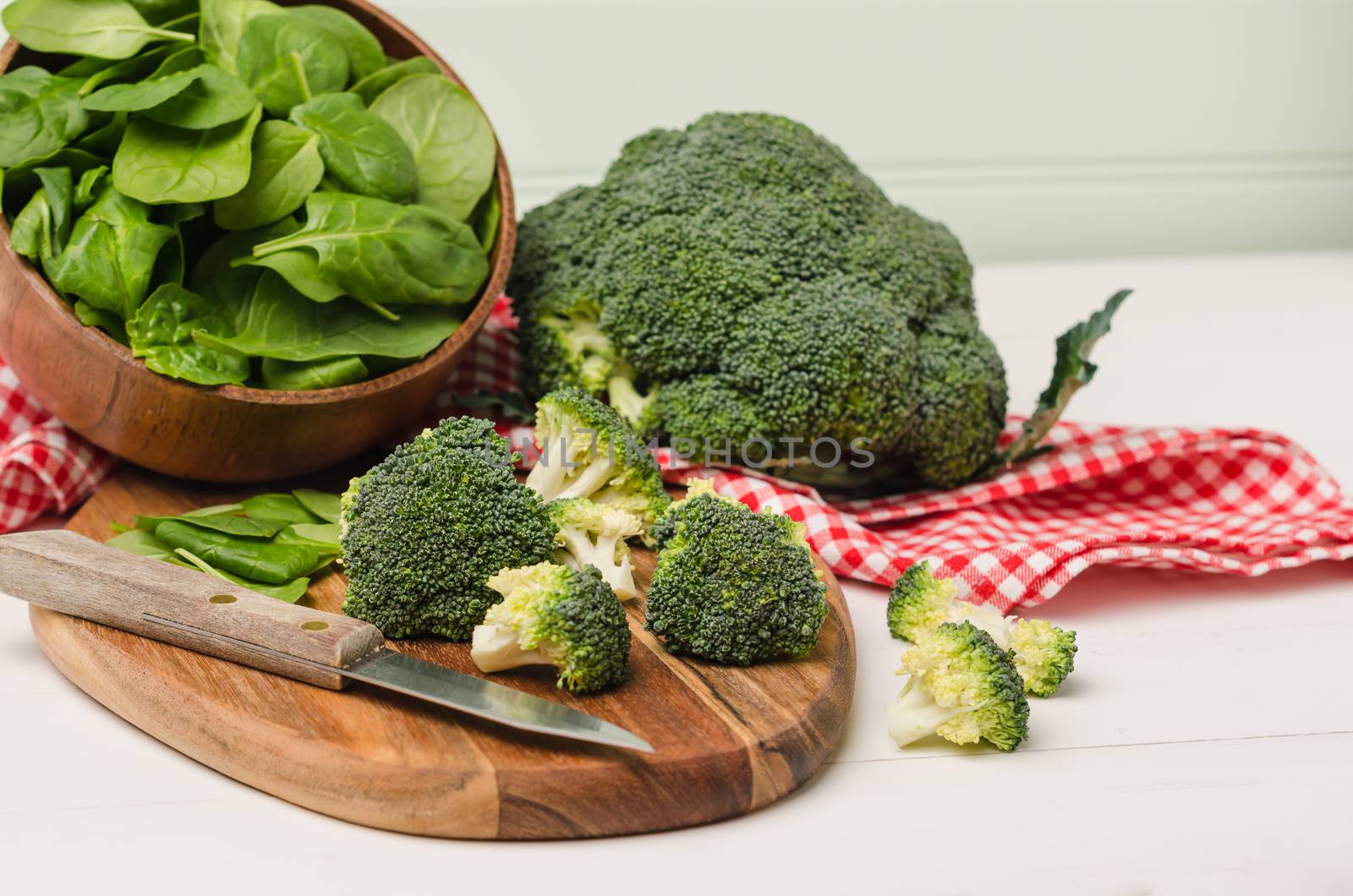 Fresh broccoli with spinach on wooden table close up by AnaMarques