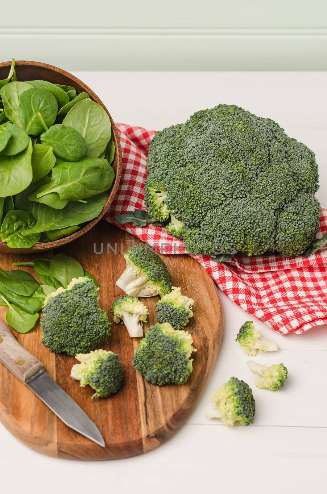 Fresh broccoli with spinach on wooden table close up by AnaMarques