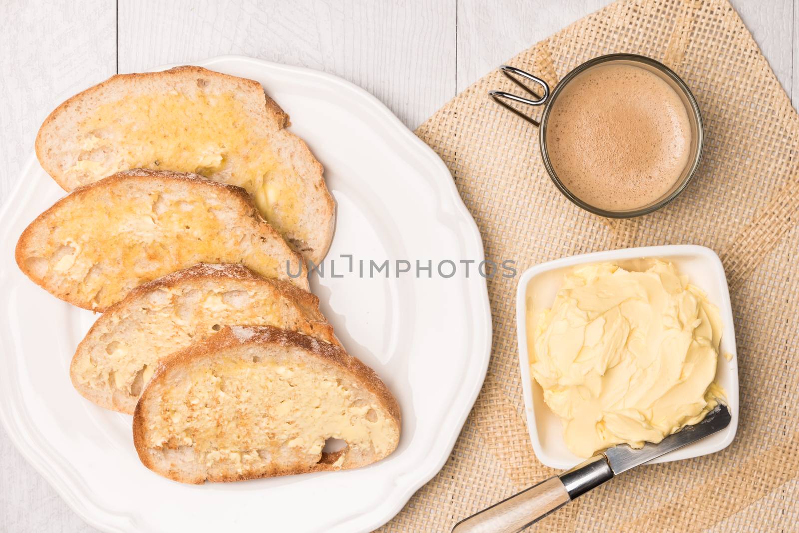 Fresh bread, homemade butter and coffee on wooden background.  by AnaMarques