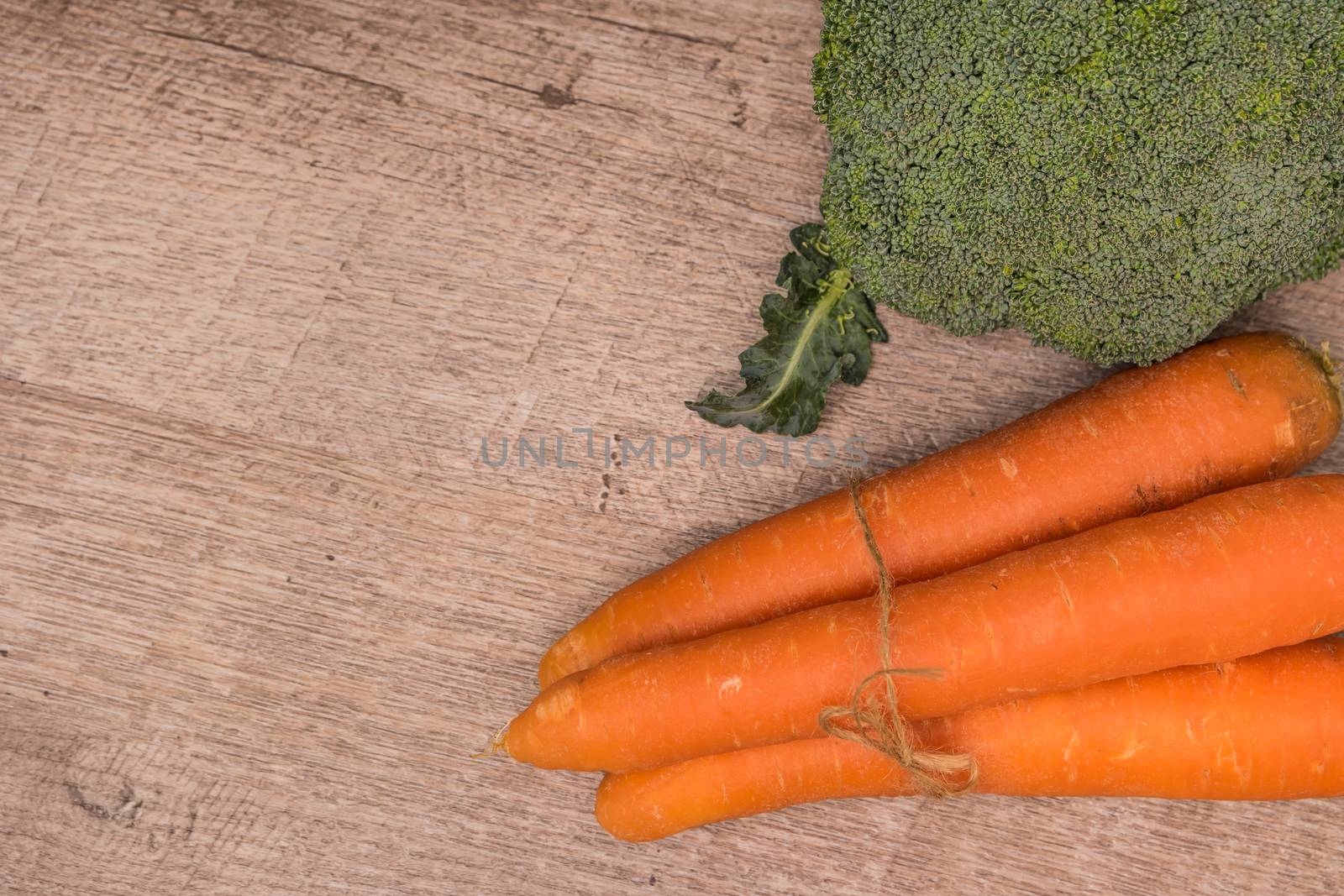 Fresh vegetables from the garden, carrots and broccoli on a wooden table. Vegetables for preparing soup