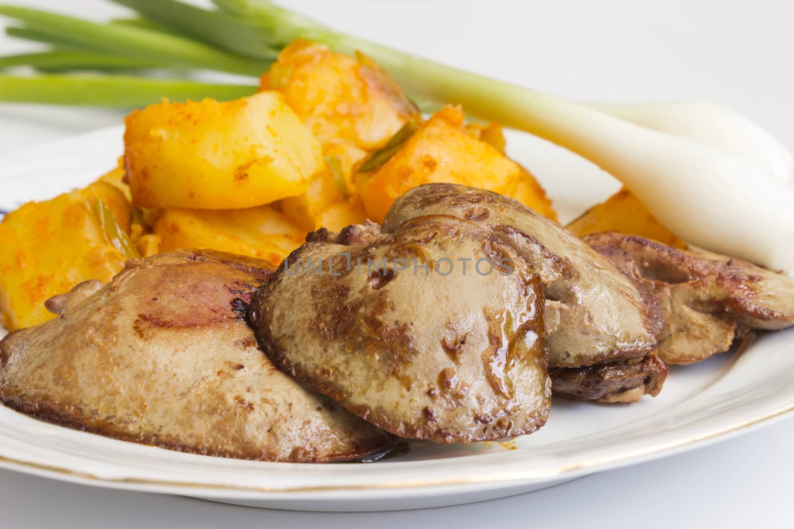 Fried liver served with potatoes and onions