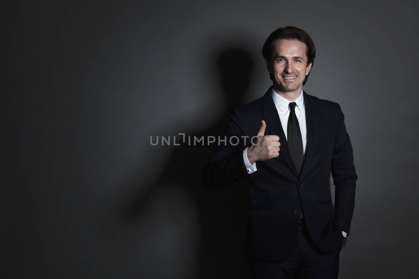 Portrait of businessman in suit on dark background