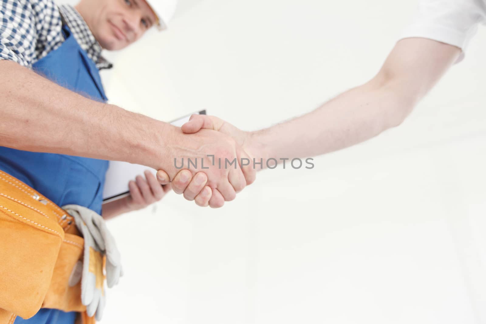 Two construction workers shaking hands, deal is finished concept