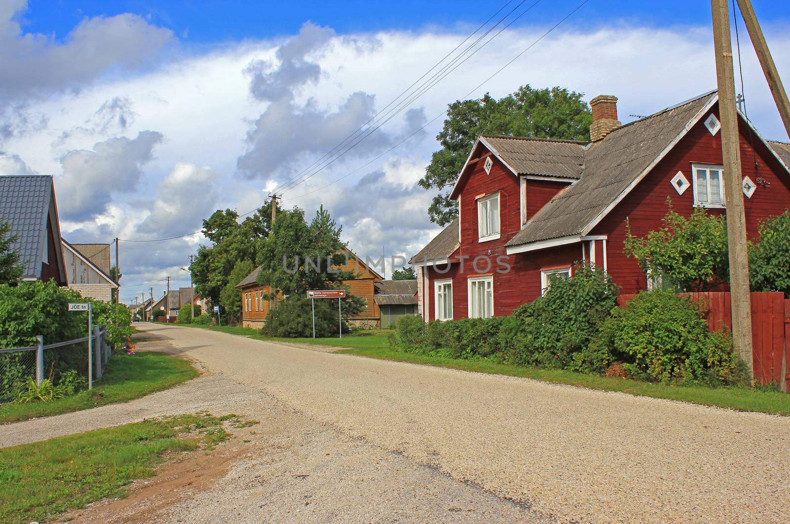 Colorful, old style houses by the village road. Cloudy sky in background. Kükita village, Peipsi, Estonia.