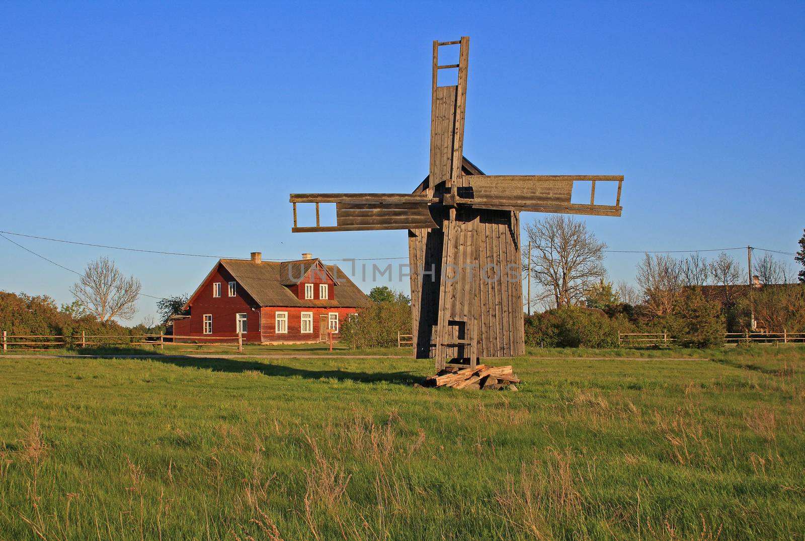 Old post windmill in Rällby village. Post mill is the earliest type of European windmill.  Soft  evening sunlight. Vormsi island, Estonia.