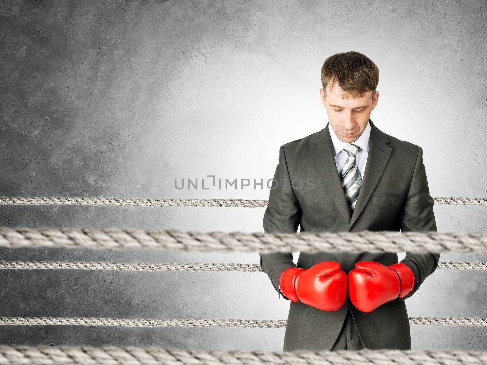 Businessman with boxing gloves on boxing ring