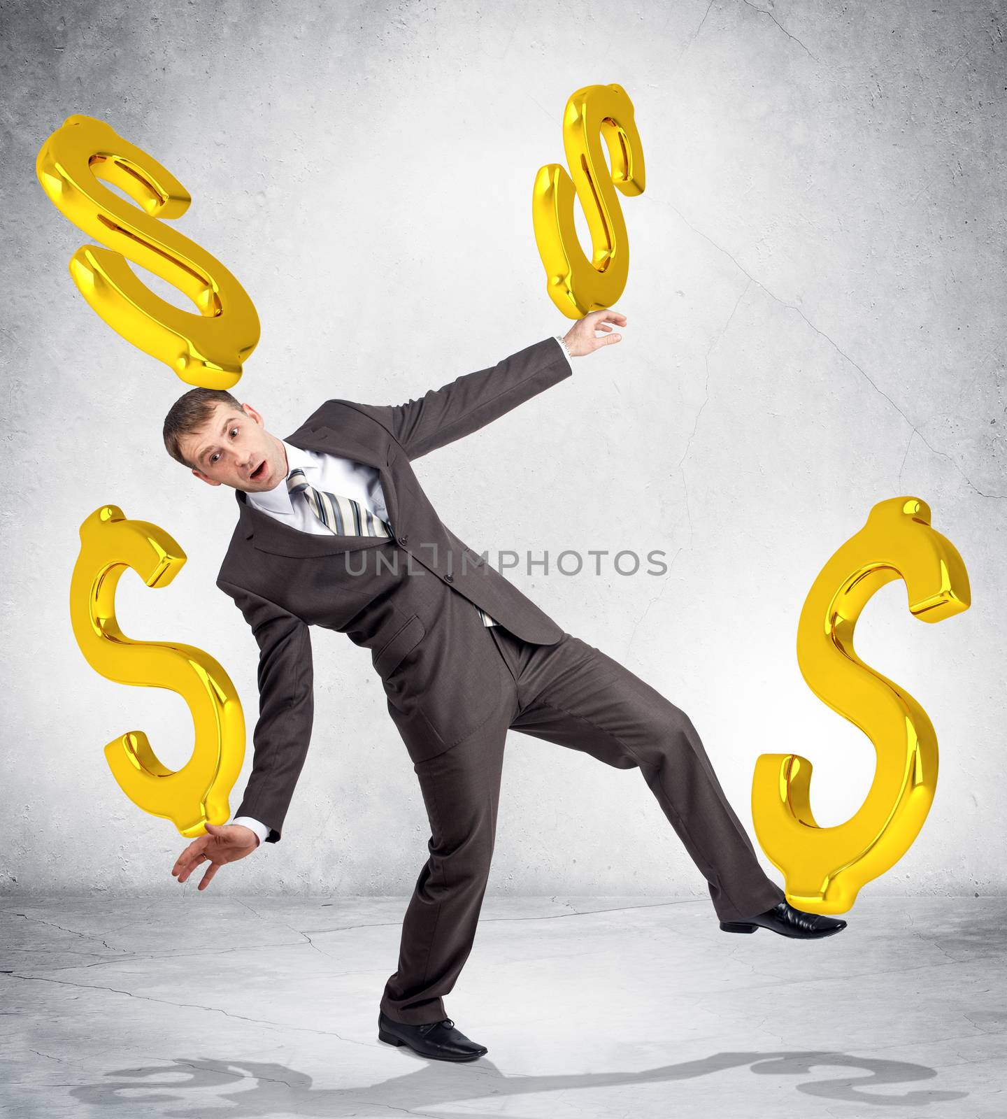 Businessman holding dollar signs on grey background