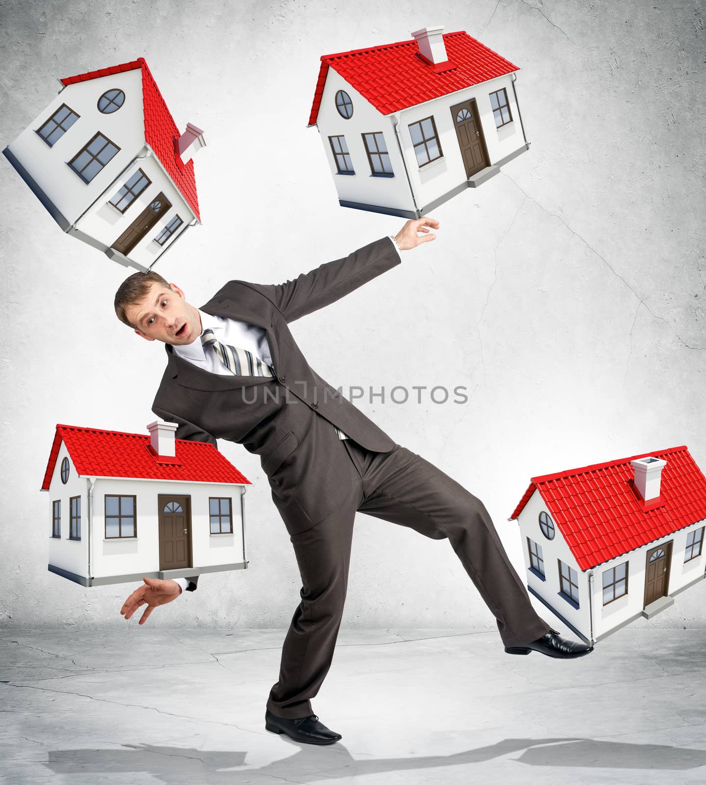 Businessman holding little houses by cherezoff