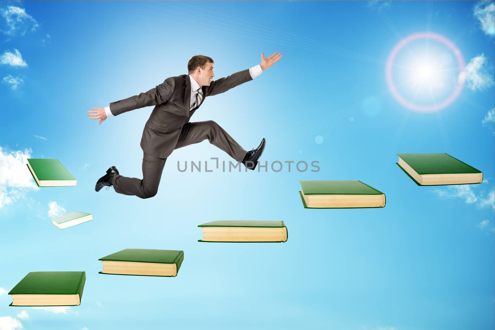 Businessman jumping over books in sky with sun
