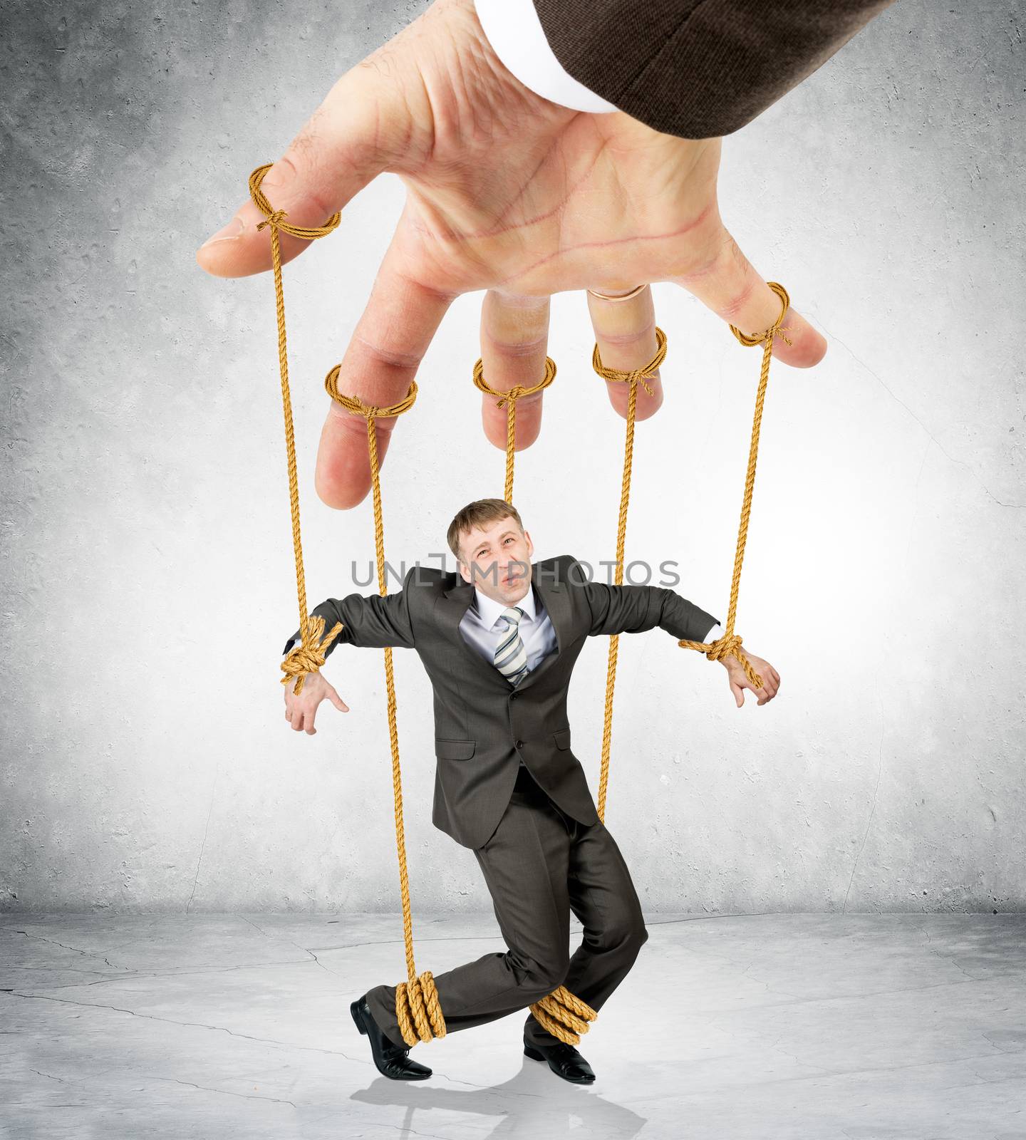 Businessman hanging on strings like marionette by cherezoff