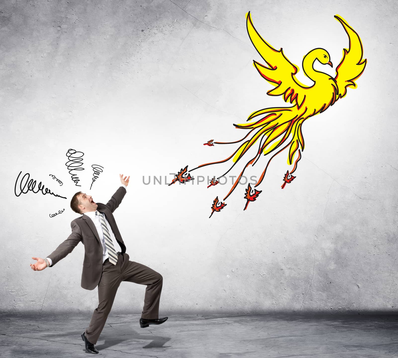 Surprised businessman looking at drawn firebird on grey background