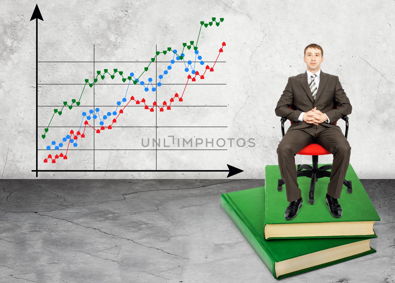 Businessman sitting on books with chart by cherezoff