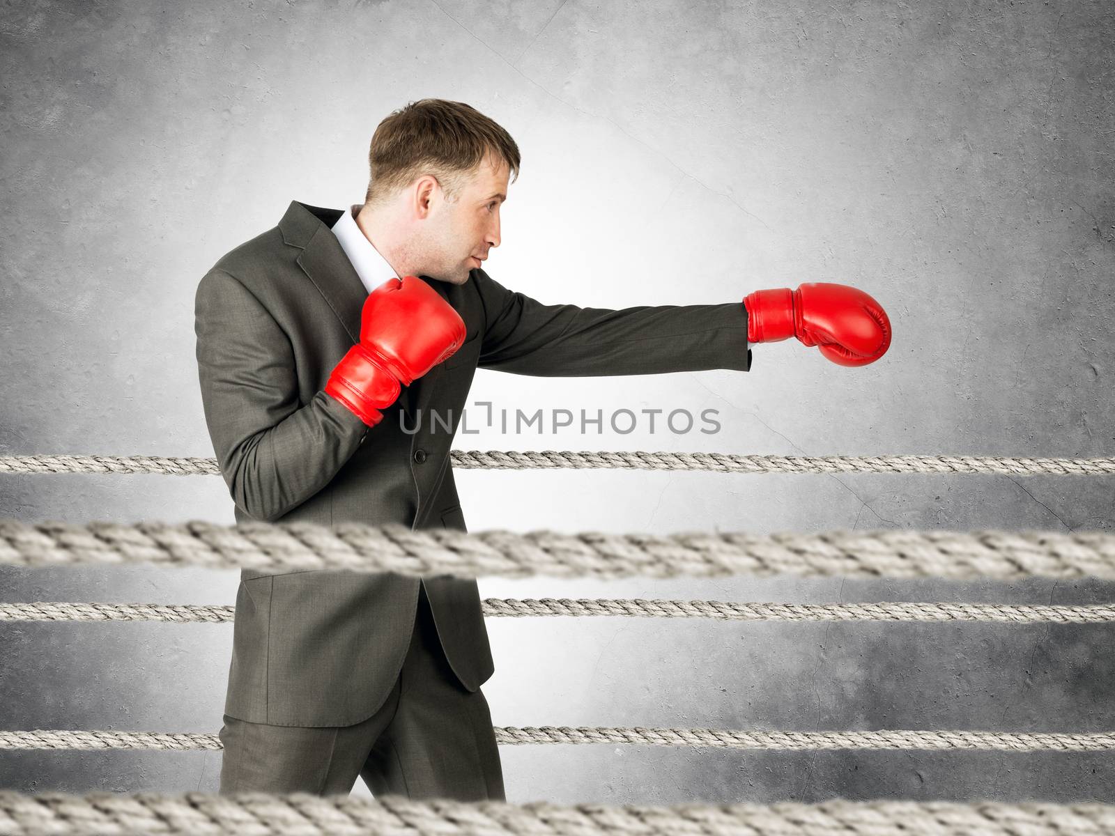 Portrait of businessman boxing on boxing ring