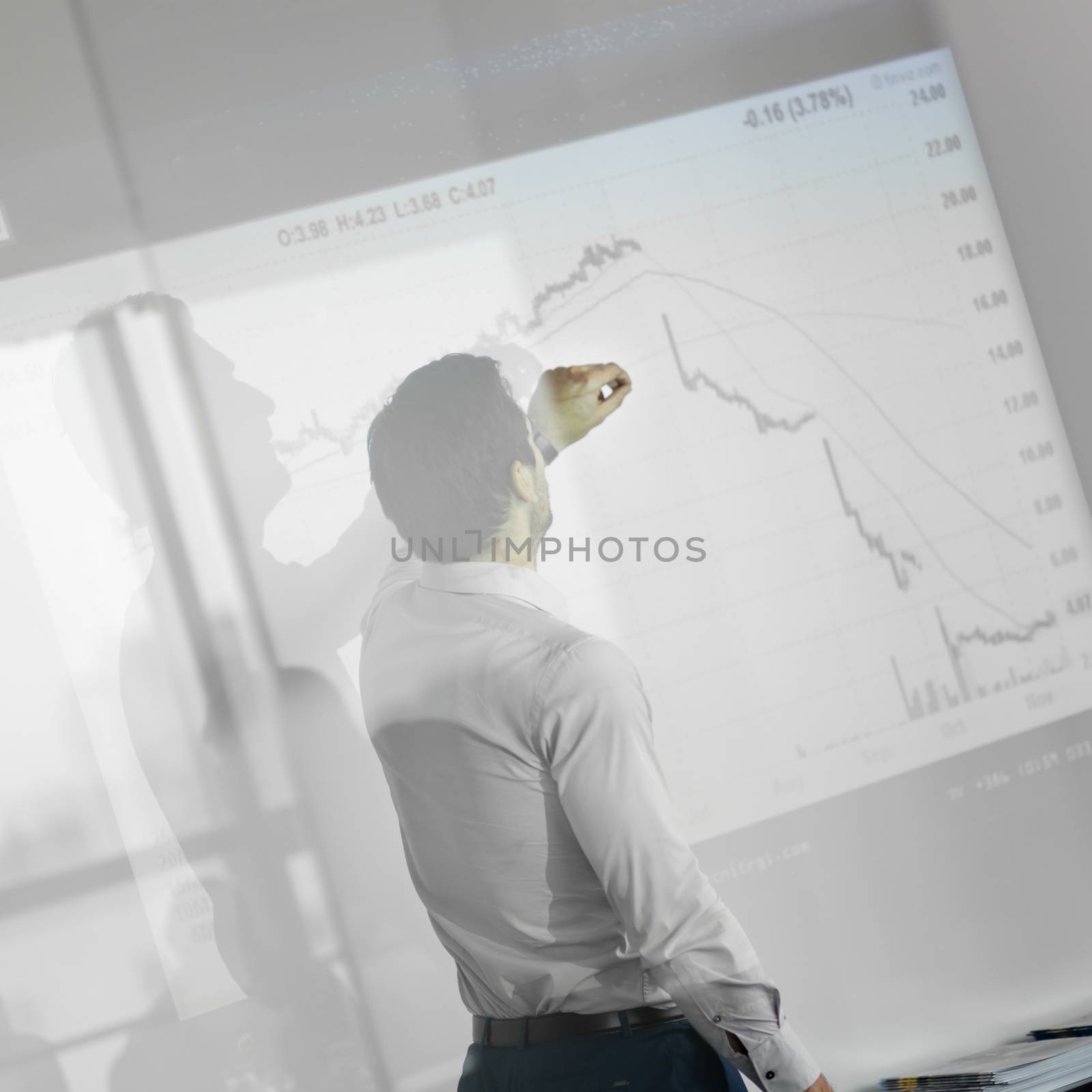 Businessman making a presentation in front of whiteboard. Business executive delivering a presentation to his colleagues during meeting or in-house business training. 