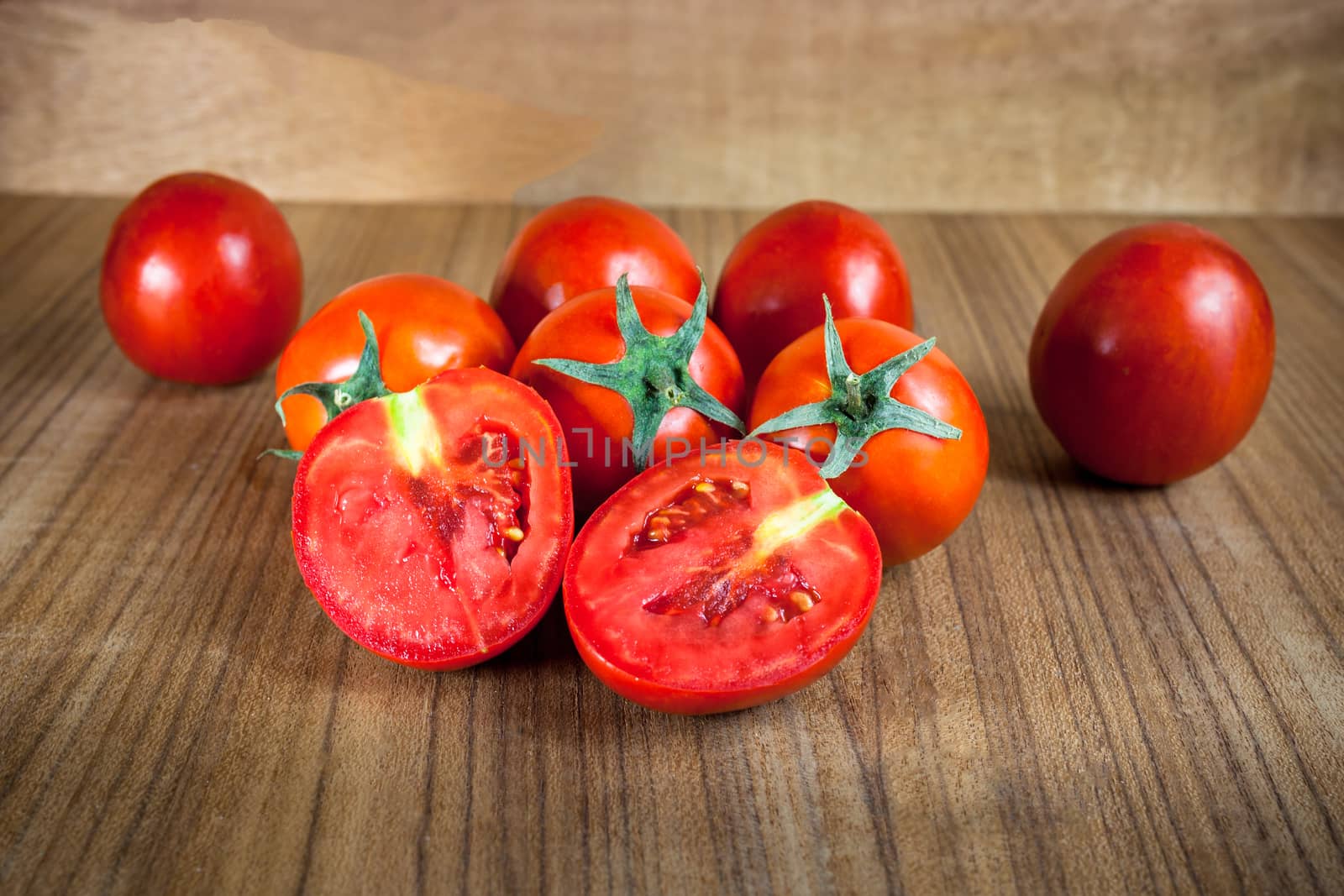 Close-up fresh ripe tomatoes on wood background by nopparats