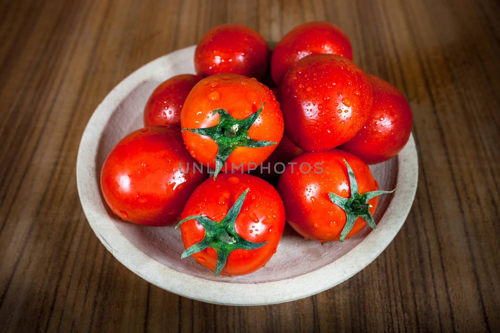 Close-up fresh ripe tomatoes on wood background by nopparats