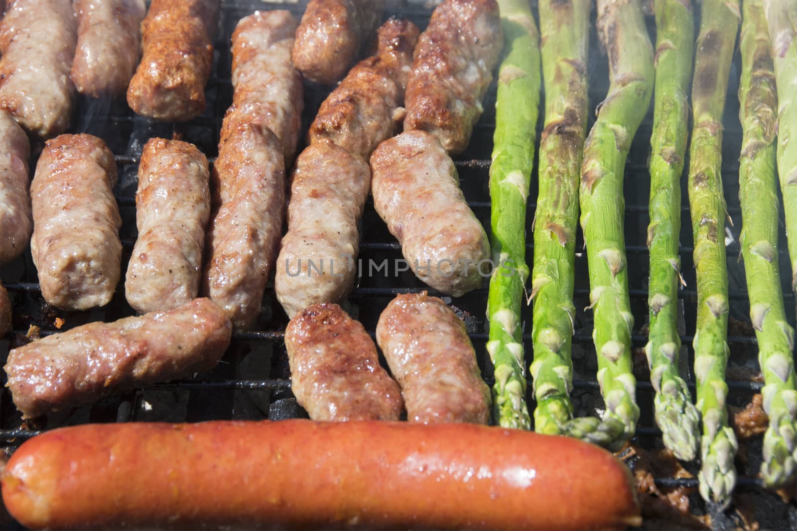 Cevapi, famous Balkan dish, sausage, and asparagus on a grill.