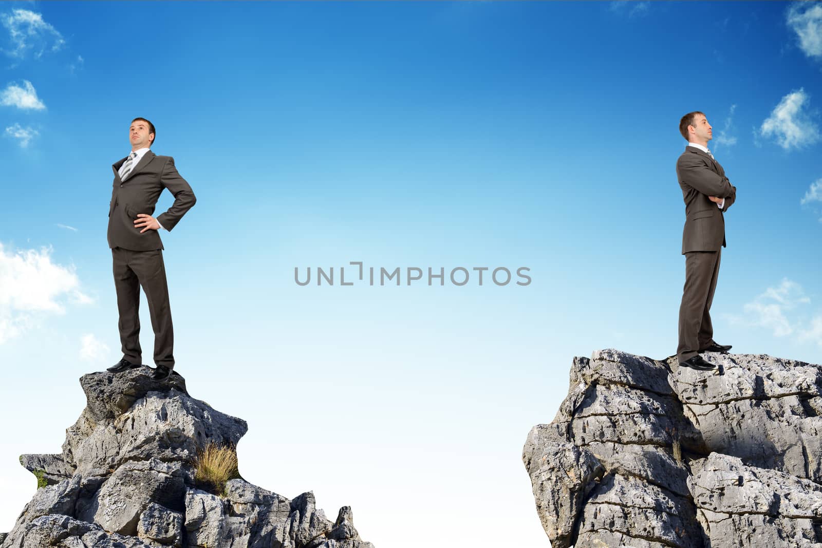 Young businessmen standing on peaks with their backs to each other
