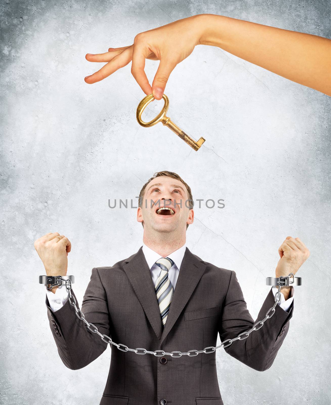 Businessman in handcuffs and big hand offering key by cherezoff