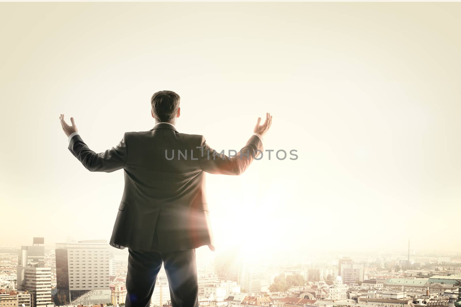 Happy businessman looks sunrise in city, concept for business