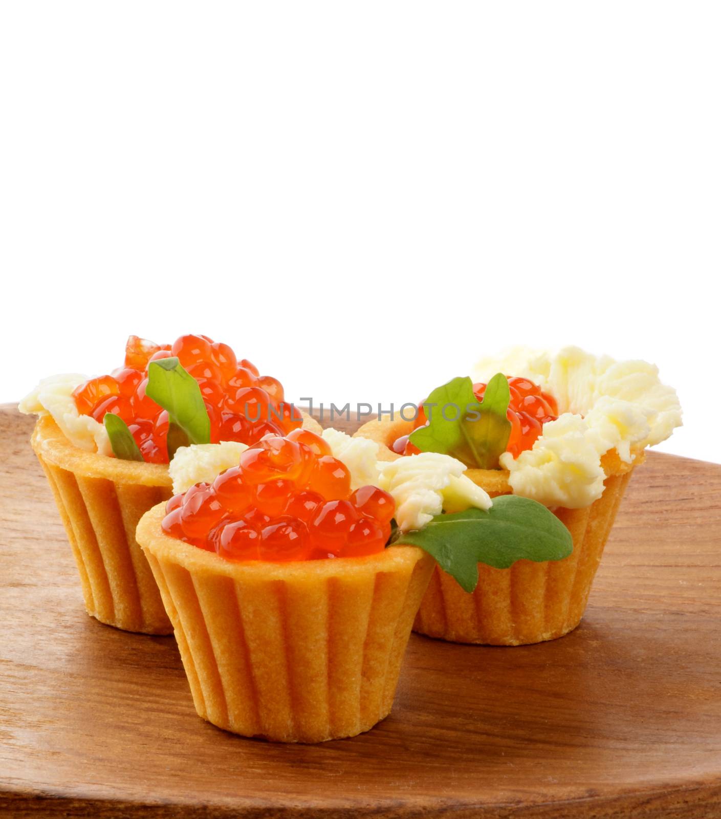 Perfect Red Caviar in Tartlets with Greens and Butter closeup on Wooden Plate 