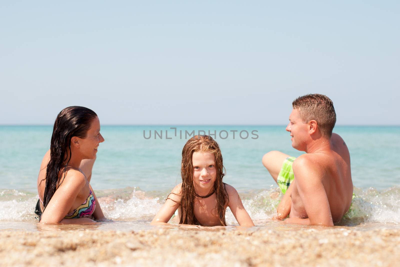 Family of three relaxing at beach