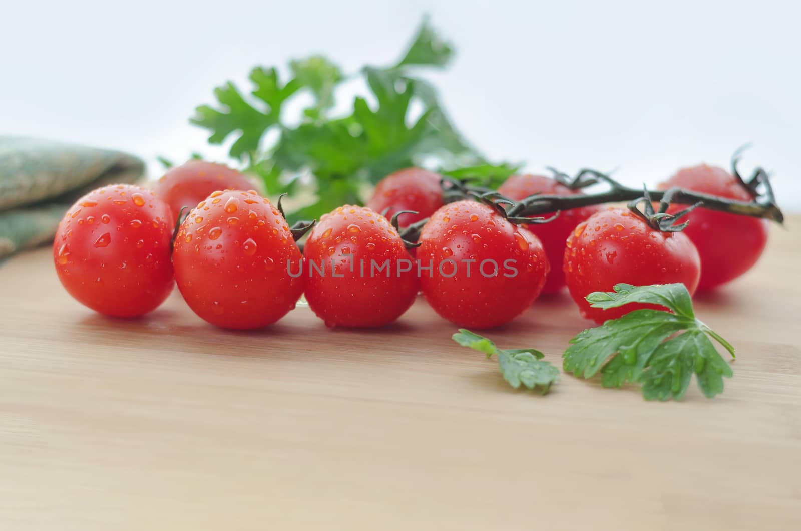 Tomatoes on a branch and parsley, are on the table, the natural light and bokeh.