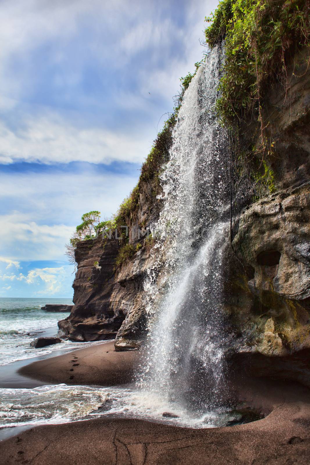 Waterfall At Melasti Beach by fotoru