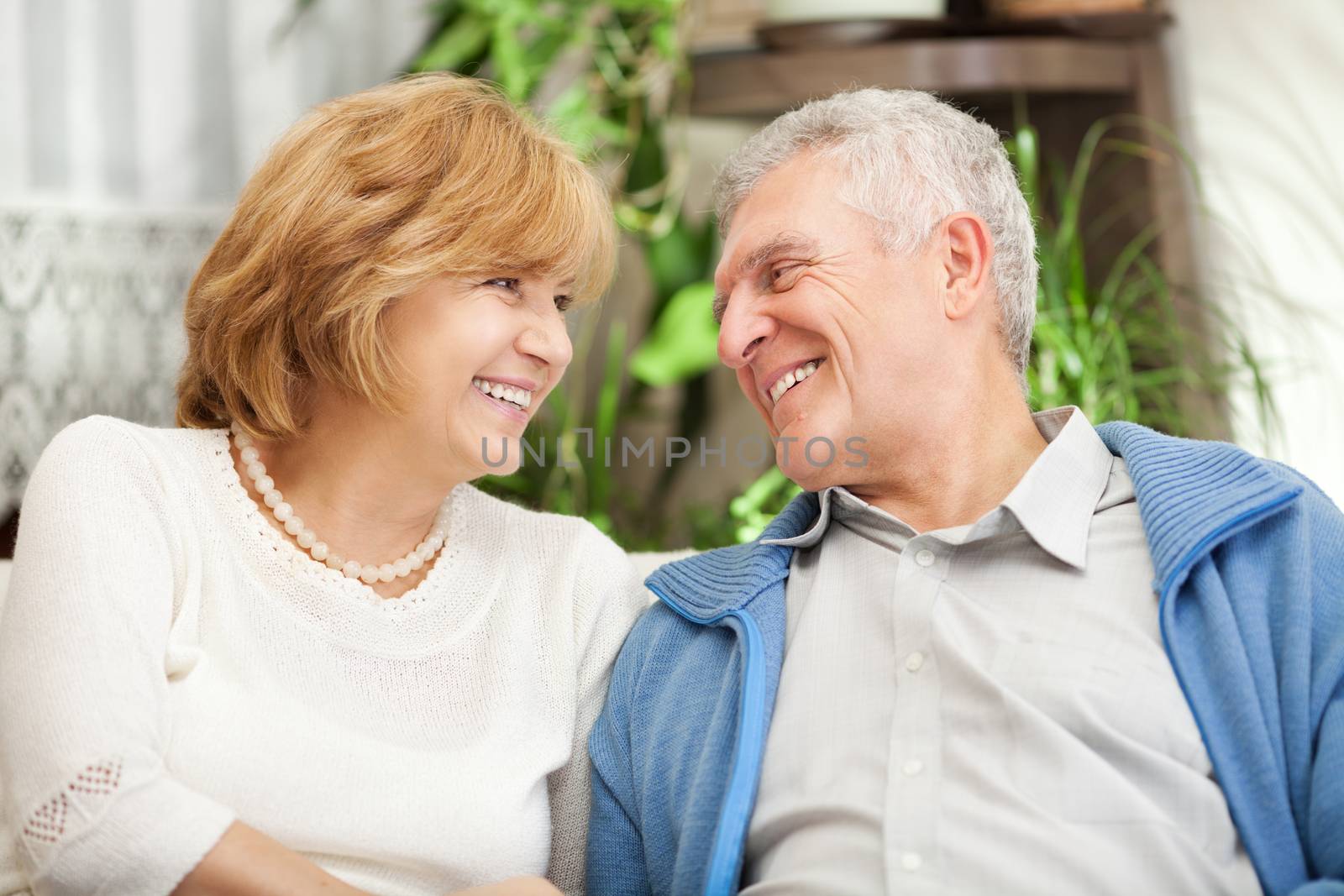 Happy senior couple in love sitting in living room