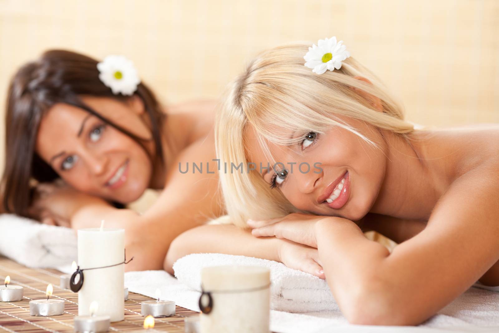 Two young beautiful women relaxing and enjoying at the spa center