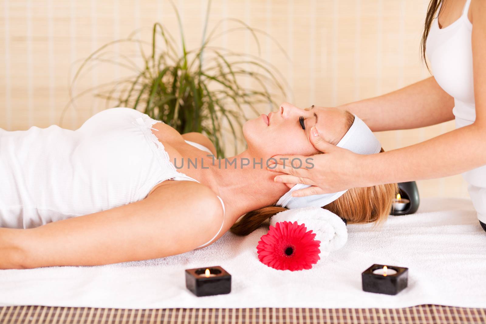 Young beautiful woman receiving head massage at the spa center