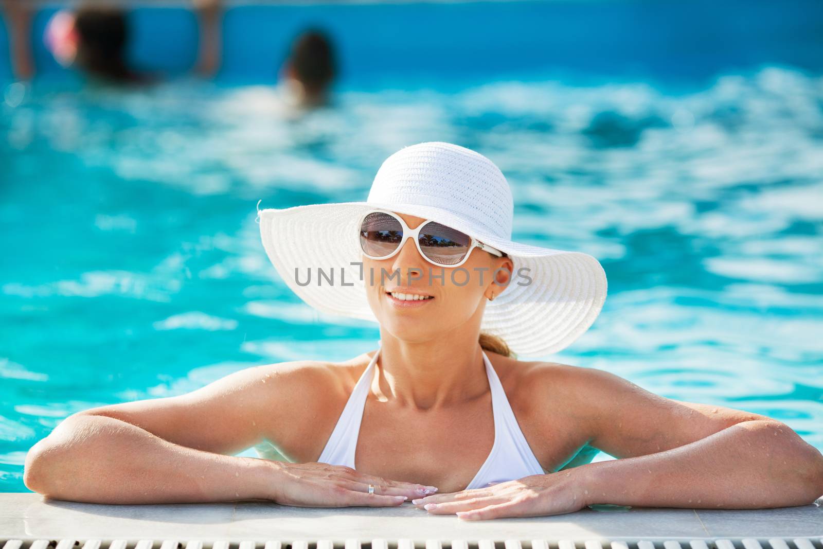 Young beautiful woman enjoying the sun in the pool