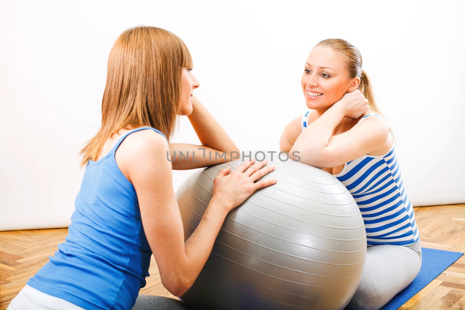 Fitness woman sitting on exercise mat and consult with Personal Trainer about training