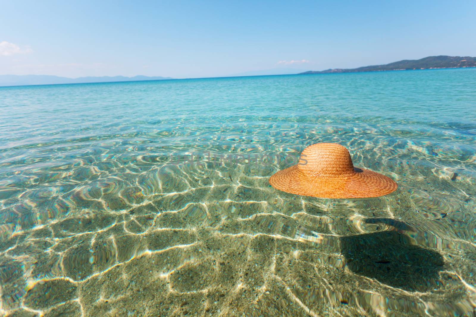 Straw sun hat float in the seawater