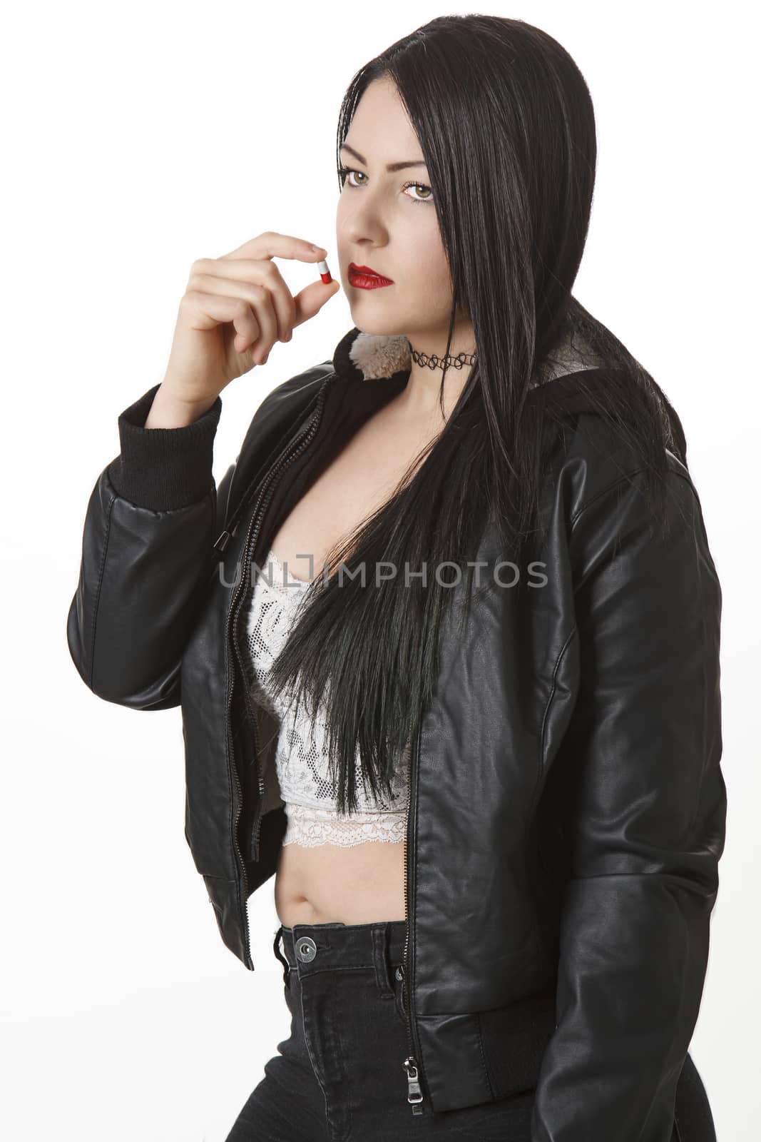 young woman with red and white pill to her lips