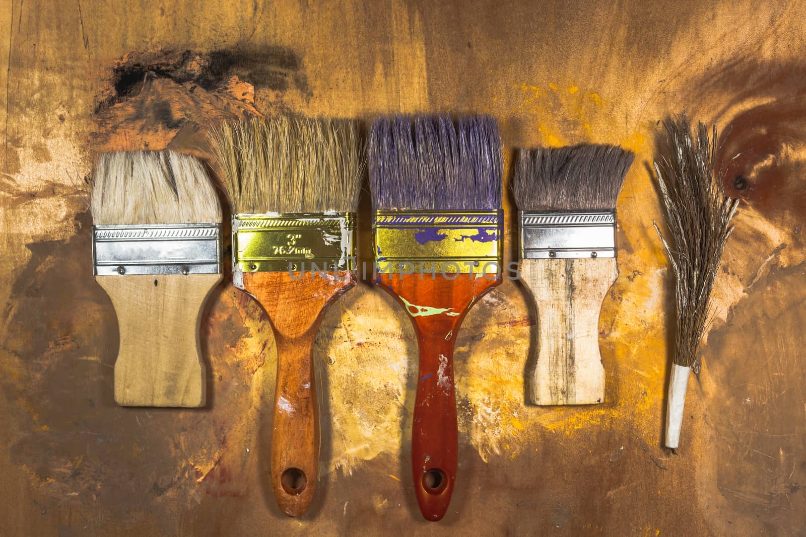 Oil paint brushes on wood painted background by nopparats