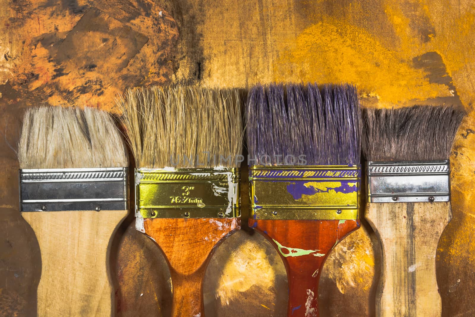 Oil paint brushes on wood painted background .