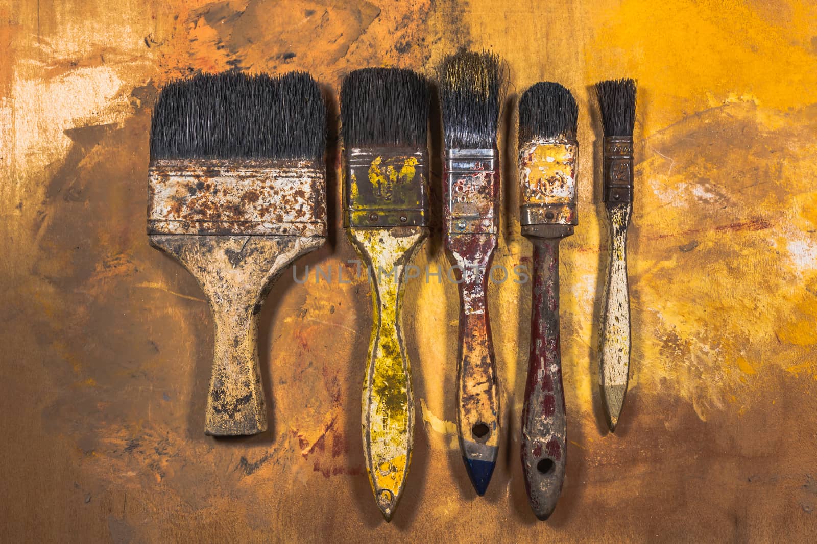 Oil paint brushes on wood painted background by nopparats
