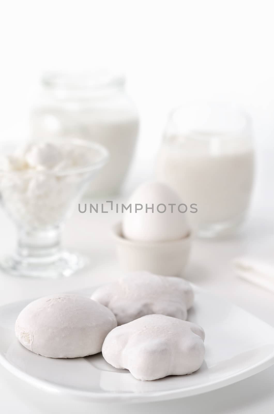 Breakfast white on white, high key and bokeh. three gingerbread, eggs,curd and milk.