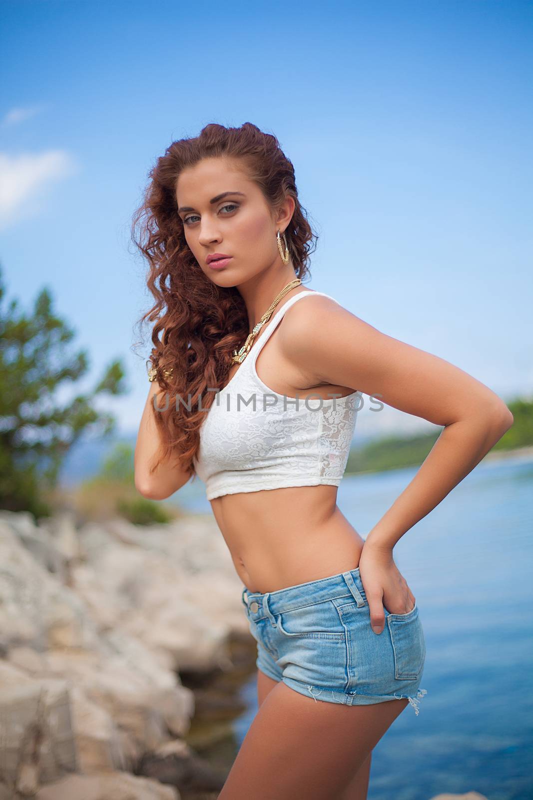 sexy girl in jean shorts on sea beach by fotoduki