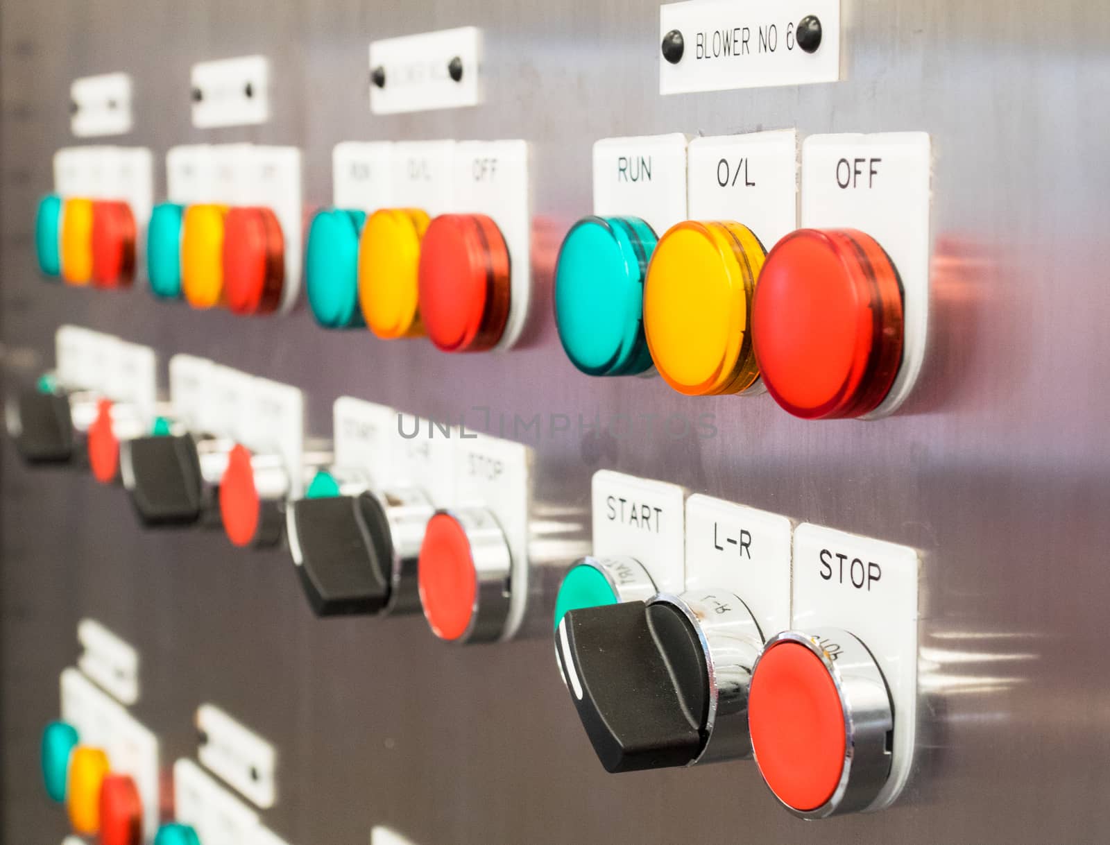 Industrial, electric switch panel with buttons in different colours. Dramatic perspective with shallow depth of field.
