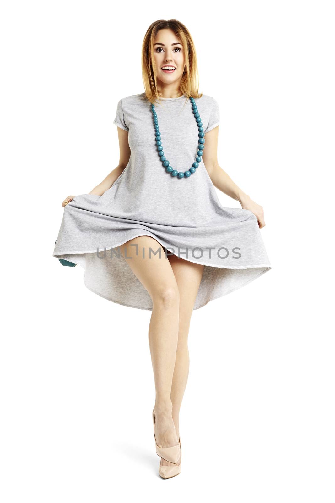 Studio shot of young woman dancing cancan. She raises a leg up.